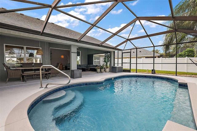 view of pool featuring glass enclosure, an outdoor hangout area, and a patio area