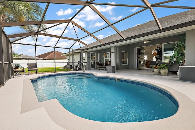 view of pool featuring glass enclosure, a patio, and ceiling fan