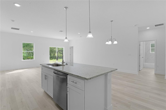 kitchen featuring dishwasher, sink, hanging light fixtures, a center island with sink, and light hardwood / wood-style floors