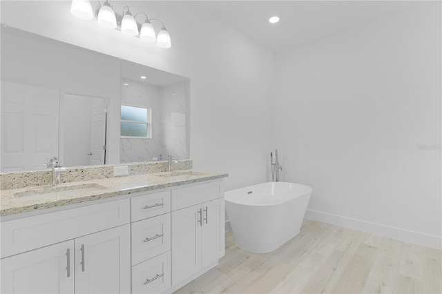 bathroom with vanity, wood-type flooring, and plus walk in shower