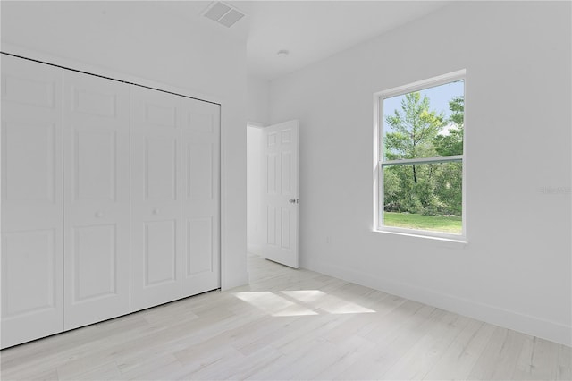 unfurnished bedroom featuring light wood-type flooring and a closet