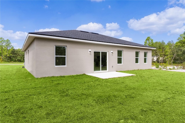 rear view of house featuring a lawn and a patio