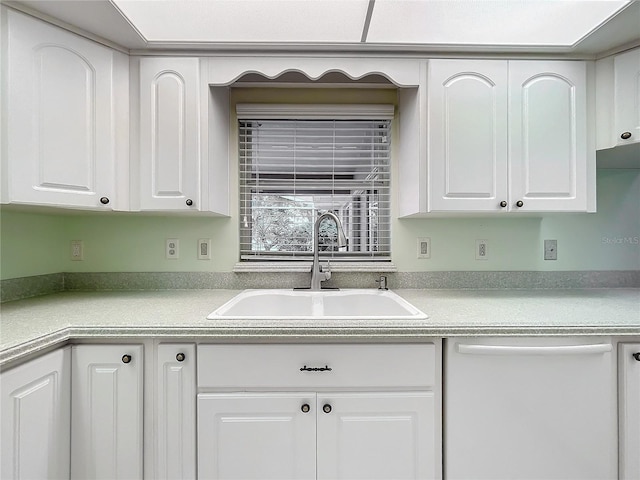 kitchen featuring white cabinets, dishwasher, and sink