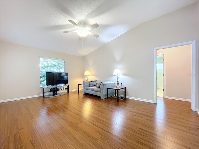 bedroom featuring light wood-type flooring, lofted ceiling, ceiling fan, and a textured ceiling