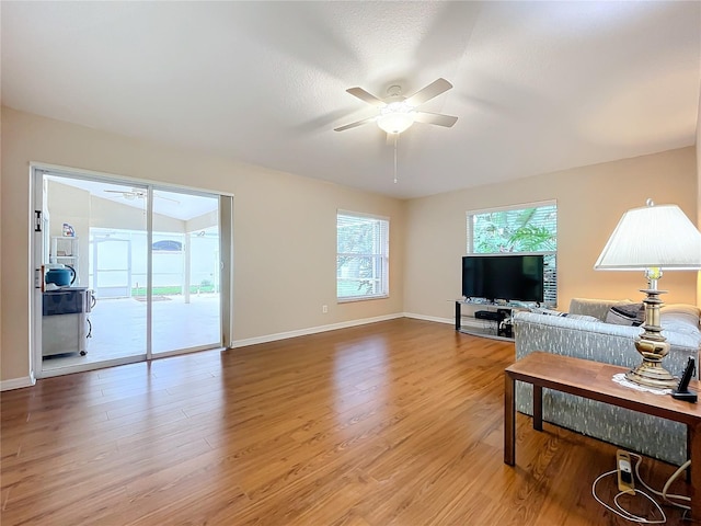 living room with ceiling fan, a textured ceiling, and light hardwood / wood-style flooring