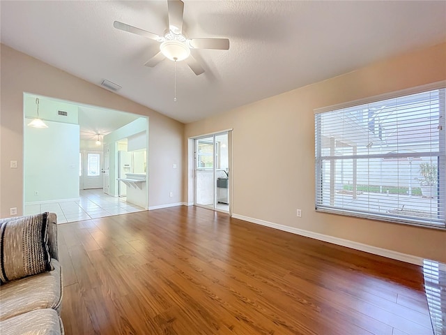 unfurnished living room featuring lofted ceiling, ceiling fan, and light hardwood / wood-style floors