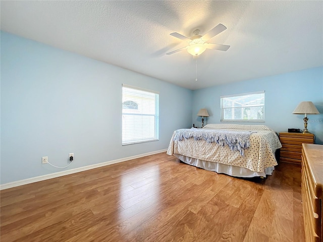 bedroom featuring a textured ceiling, ceiling fan, and hardwood / wood-style flooring