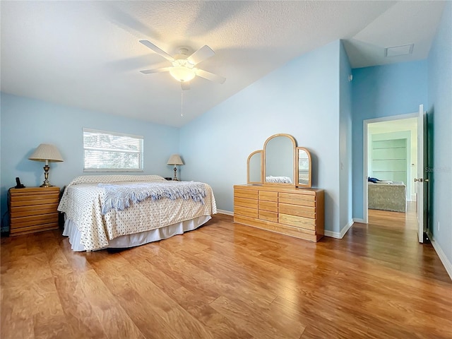 bedroom featuring lofted ceiling, ceiling fan, hardwood / wood-style flooring, and a textured ceiling