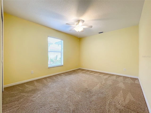 carpeted spare room with a textured ceiling and ceiling fan