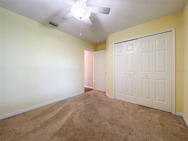 unfurnished bedroom featuring carpet flooring, a textured ceiling, ceiling fan, and a closet