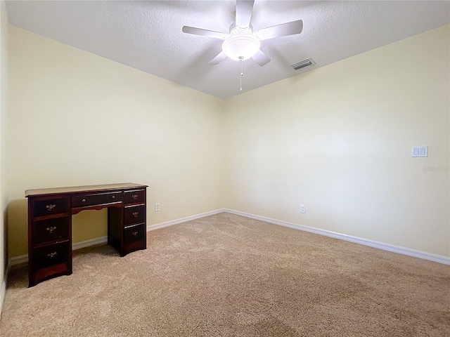 carpeted spare room featuring ceiling fan and a textured ceiling