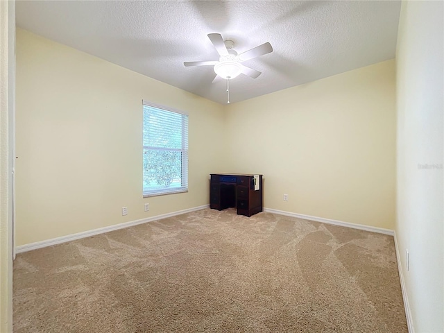 carpeted spare room with a textured ceiling and ceiling fan