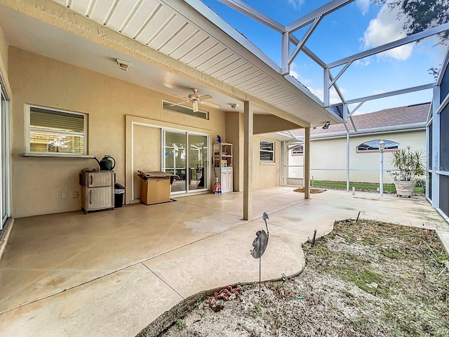 view of patio with glass enclosure and ceiling fan