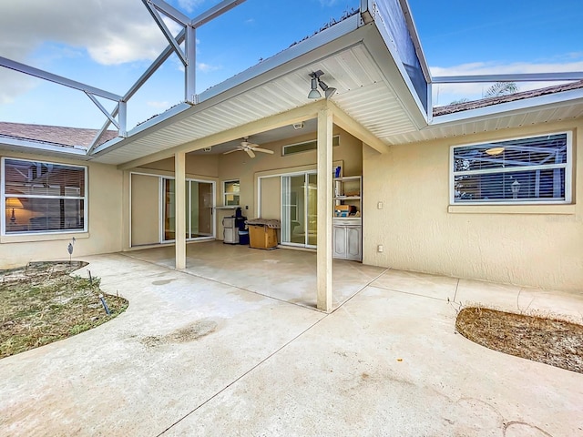 rear view of property featuring a lanai, ceiling fan, and a patio area