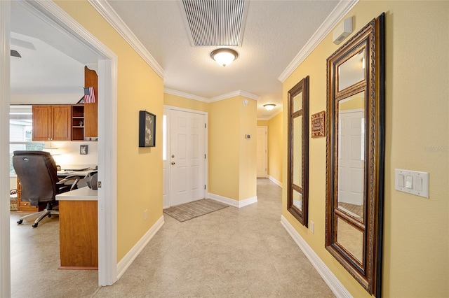 entryway with ornamental molding and a textured ceiling