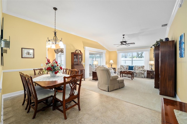 carpeted dining room featuring ceiling fan with notable chandelier, ornamental molding, and lofted ceiling