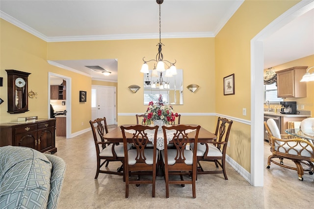 dining area with sink, a chandelier, and ornamental molding