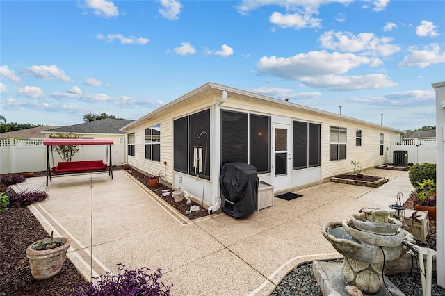 back of property featuring a sunroom, a patio area, and central AC