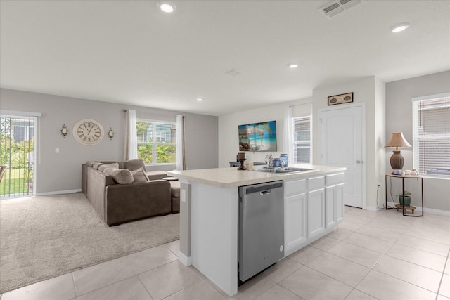 kitchen featuring a kitchen island with sink, white cabinets, sink, stainless steel dishwasher, and light tile patterned flooring