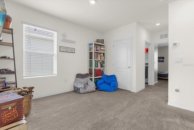 miscellaneous room featuring light colored carpet