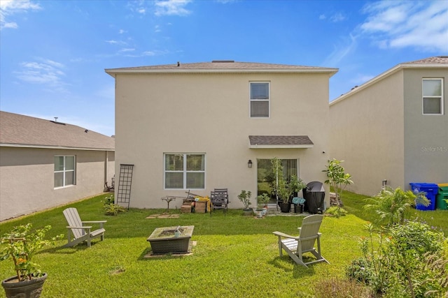 rear view of property with a lawn and an outdoor fire pit