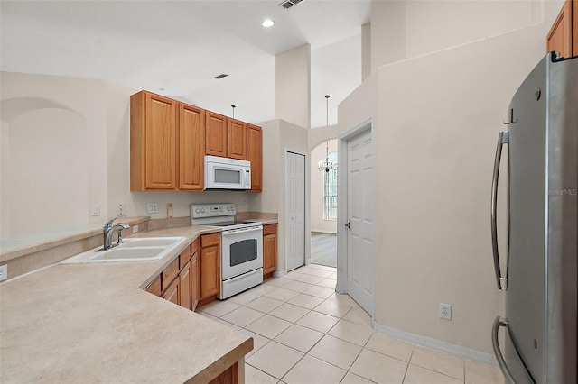 kitchen featuring sink, light tile patterned floors, and white appliances