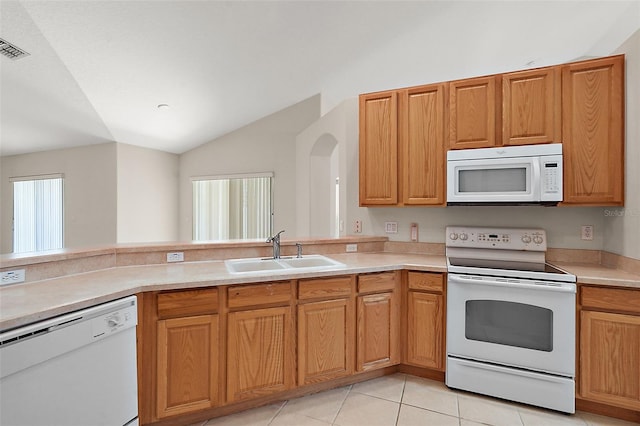 kitchen with lofted ceiling, sink, white appliances, and light tile patterned flooring