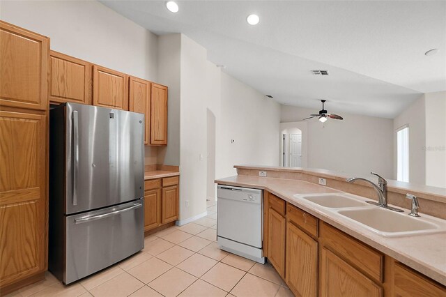 kitchen featuring dishwasher, vaulted ceiling, stainless steel refrigerator, sink, and ceiling fan