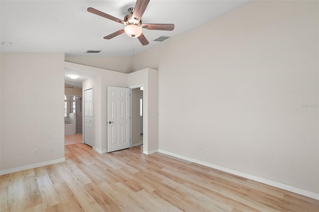 empty room featuring lofted ceiling, ceiling fan, and light wood-type flooring