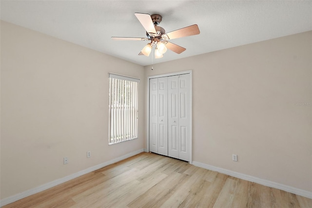 unfurnished bedroom featuring light hardwood / wood-style flooring, ceiling fan, and a closet