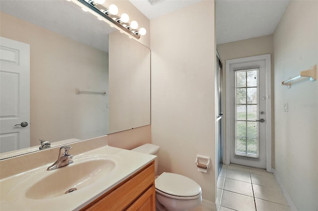 bathroom with vanity, toilet, and tile patterned floors