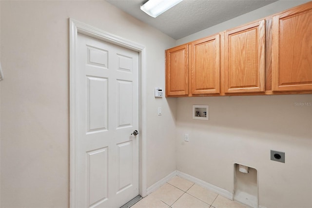 clothes washing area with cabinets, hookup for a washing machine, a textured ceiling, light tile patterned floors, and hookup for an electric dryer