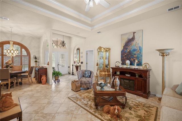 living room featuring ceiling fan with notable chandelier and crown molding