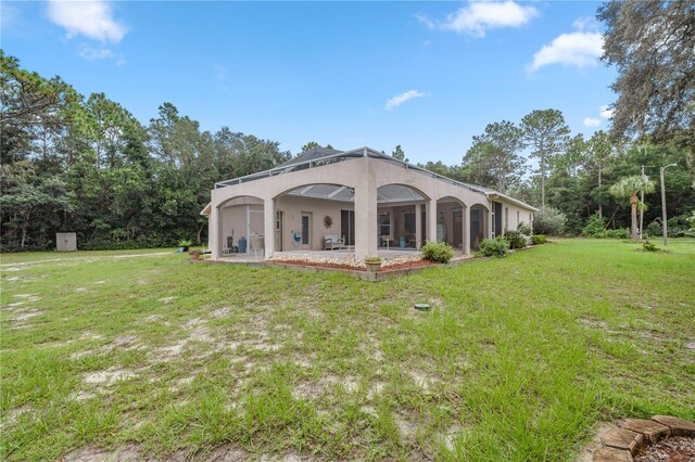 back of property with a lawn and a patio area