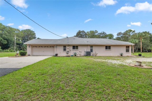 ranch-style home featuring a garage, central AC, and a front yard