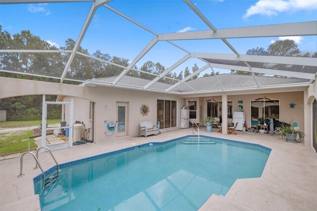 view of pool with ceiling fan, a patio area, and glass enclosure