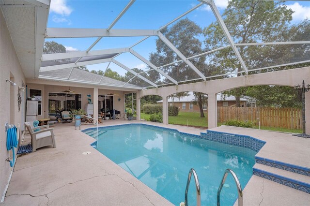 view of swimming pool featuring a lanai, ceiling fan, and a patio