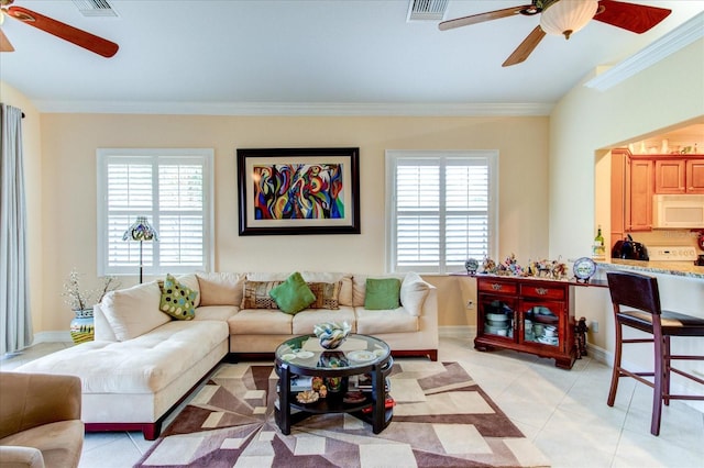 living room with ornamental molding, a healthy amount of sunlight, light tile patterned floors, and ceiling fan