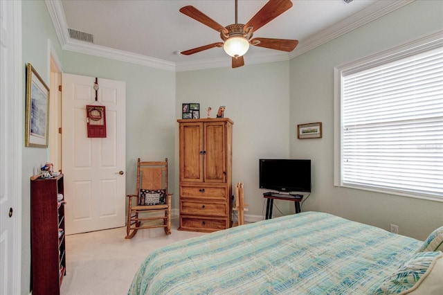 carpeted bedroom with ornamental molding and ceiling fan