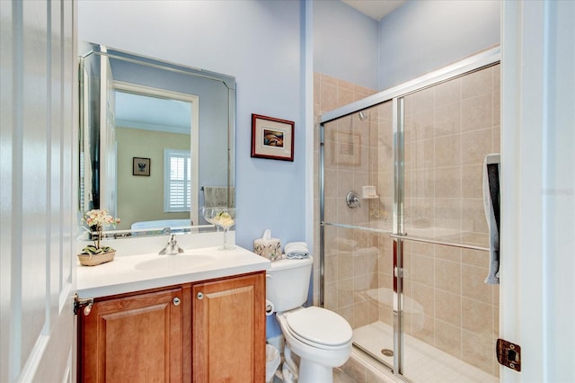 bathroom featuring vanity, toilet, and a shower with shower door