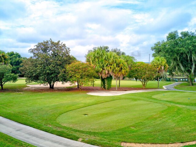 view of home's community with a water view and a lawn