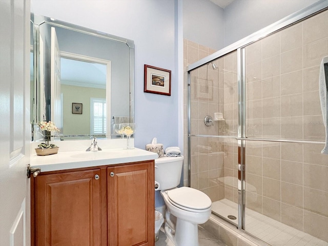 bathroom featuring tile patterned flooring, crown molding, toilet, a shower with shower door, and vanity