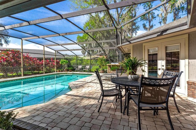 view of pool featuring a patio area, glass enclosure, and french doors