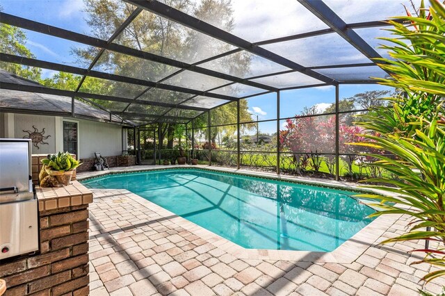 view of swimming pool featuring a patio area and a lanai