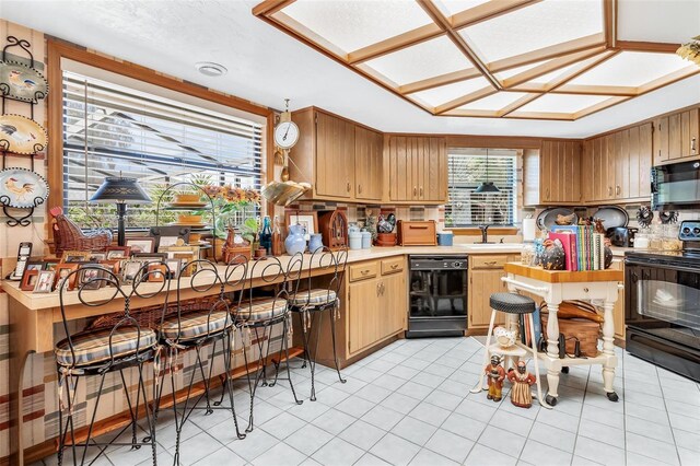 kitchen featuring black appliances, light tile patterned floors, and sink