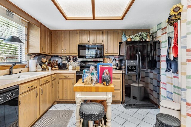 kitchen featuring black appliances, sink, and light tile patterned flooring