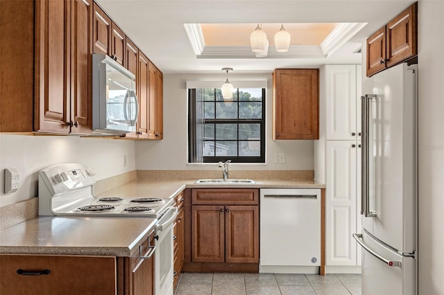 kitchen with light tile patterned floors, white appliances, sink, a raised ceiling, and ornamental molding