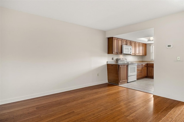 kitchen featuring white appliances and light hardwood / wood-style flooring