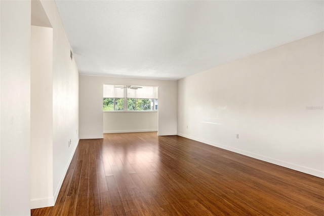 spare room featuring dark hardwood / wood-style flooring and a textured ceiling