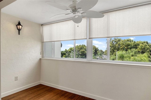 spare room with plenty of natural light, ceiling fan, and dark hardwood / wood-style floors